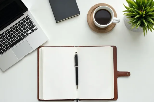 Aufger&auml;umter Schreibtisch mit Laptop und Notizbuch